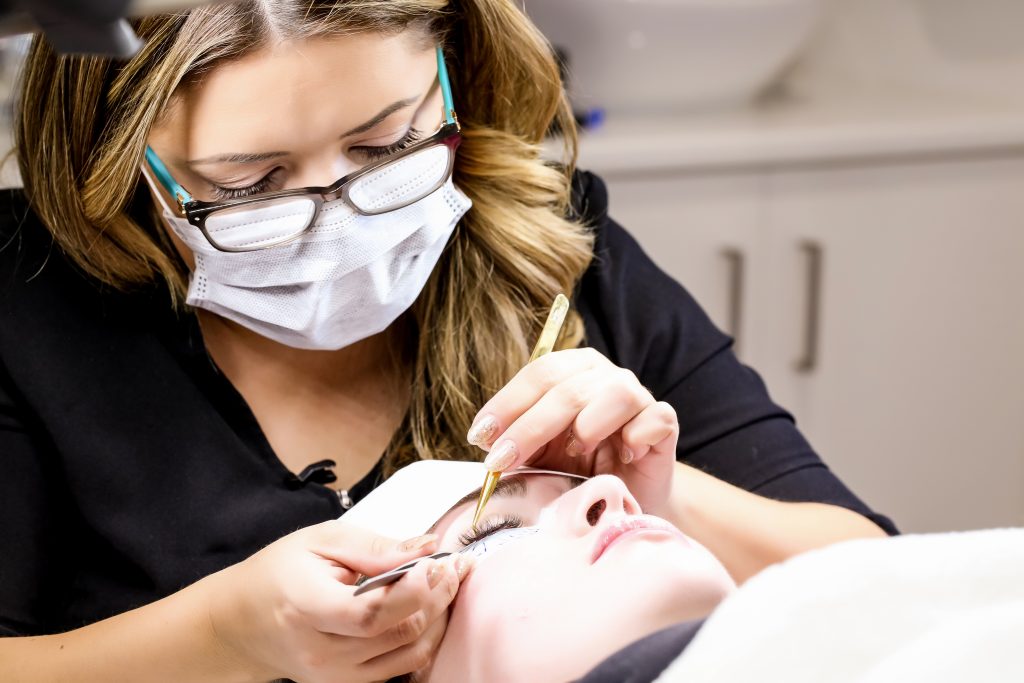 Julia Mann applying eyelash extensions to a client