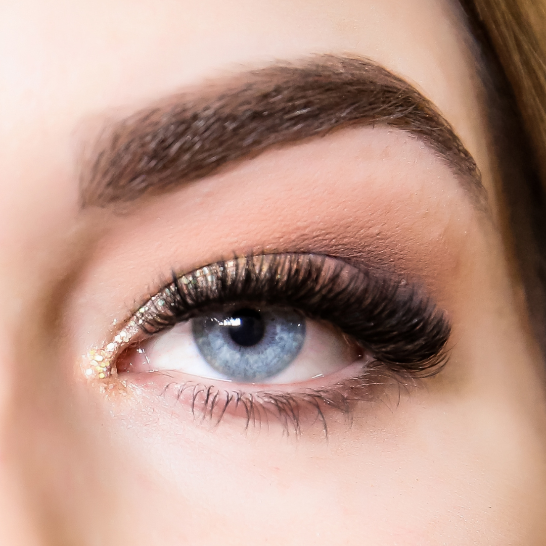 A close up of a woman's eye with gold eyelashes featuring the Lash Tribe KICK START Bundle | 3 in 1 Online Lash Course by Lash Tribe.