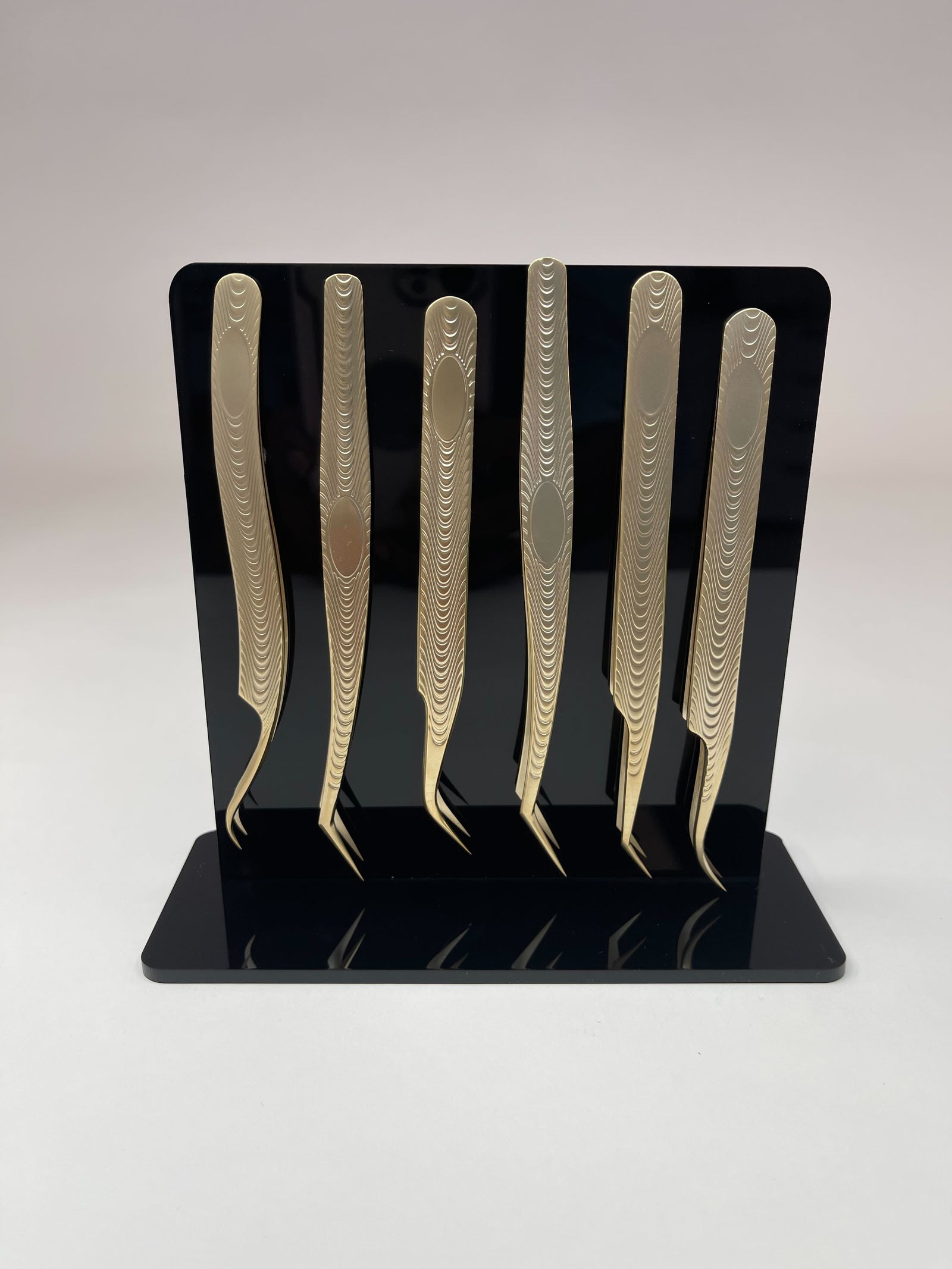 A set of Lash Tribe Magnetic Tweezer Stands on a black stand with magnetic capabilities.