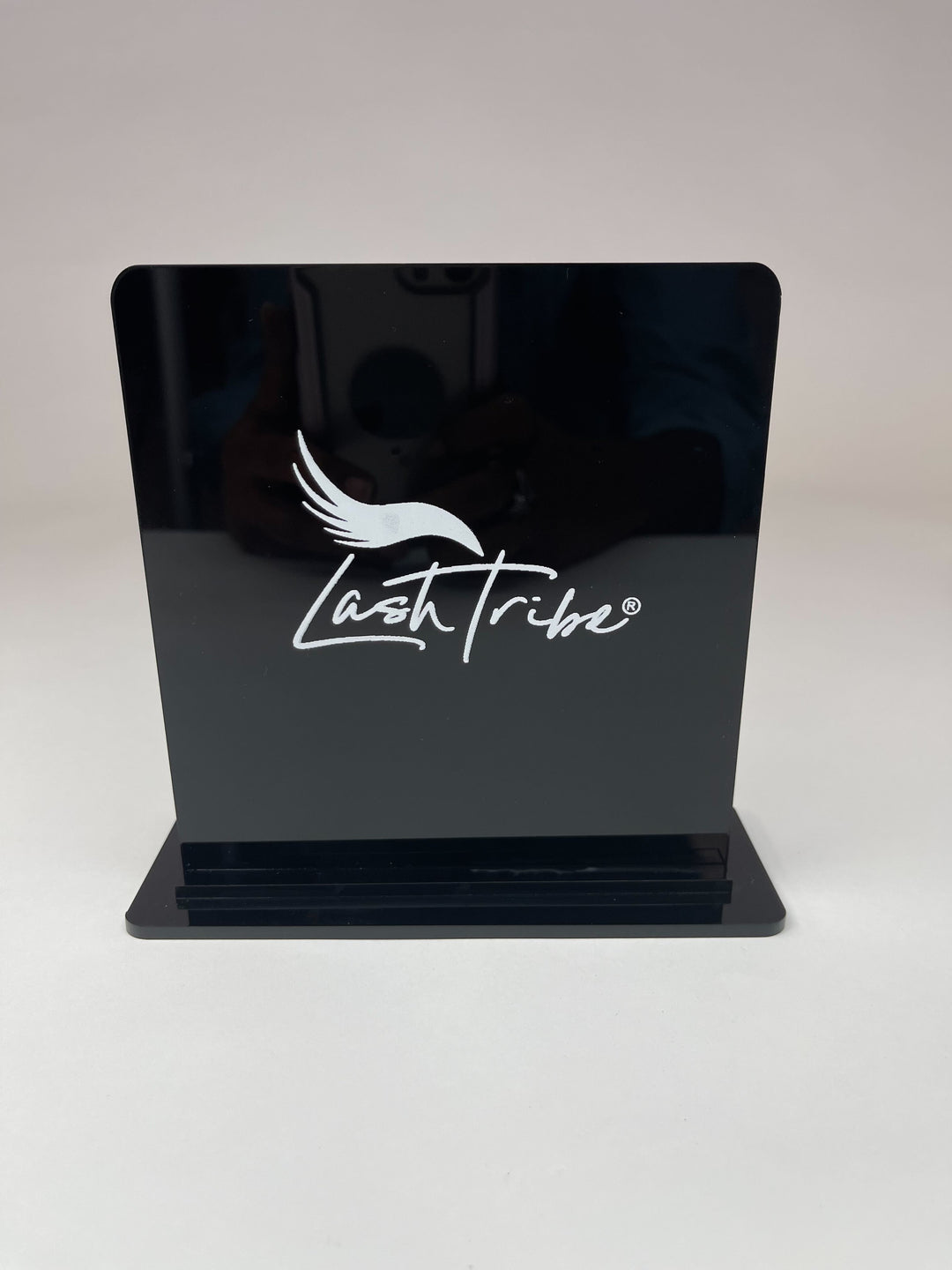 An ultra sleek Lash Tribe Magnetic Tweezer Stand with a white logo on it.