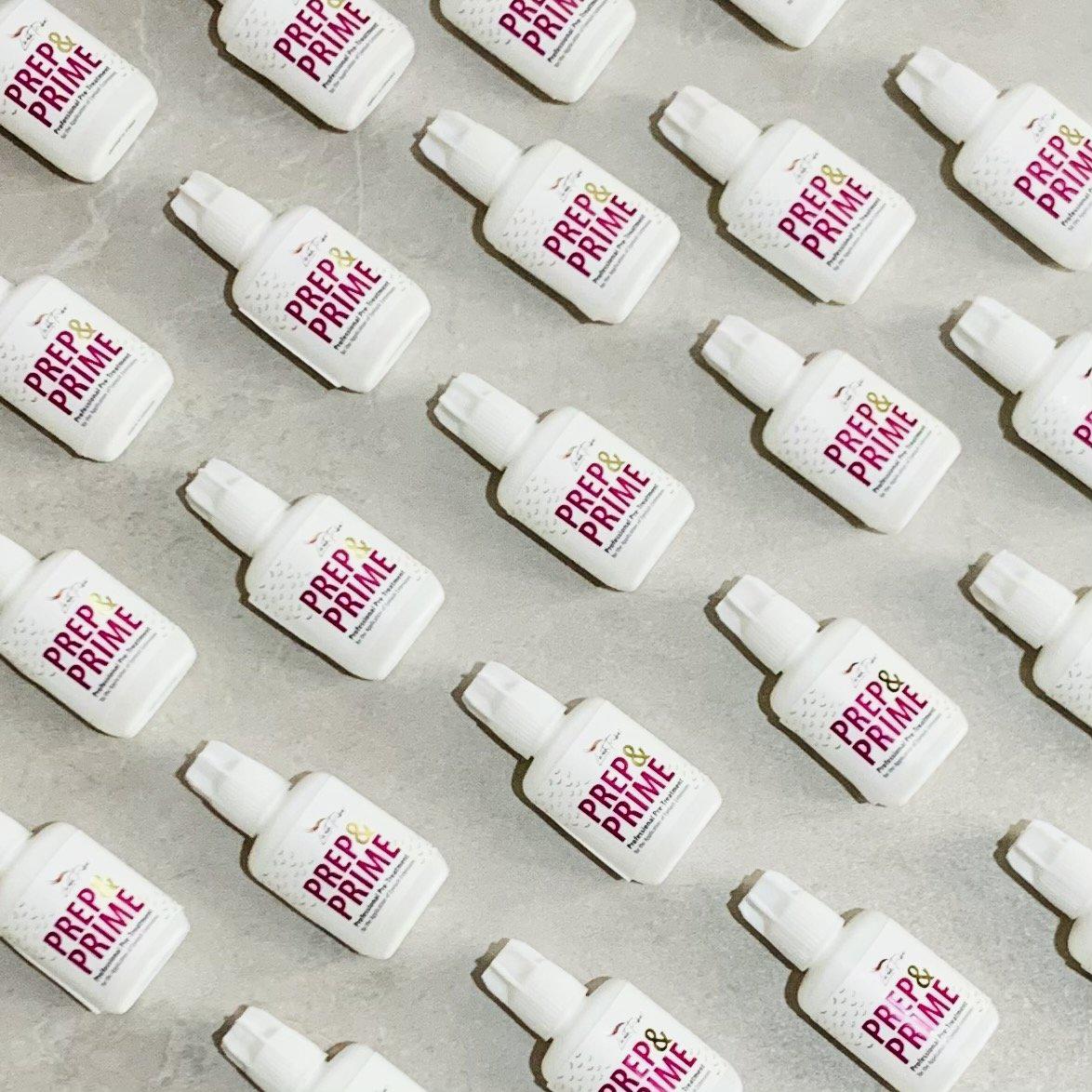 a group of Lash Tribe white bottles with a pink label on them.